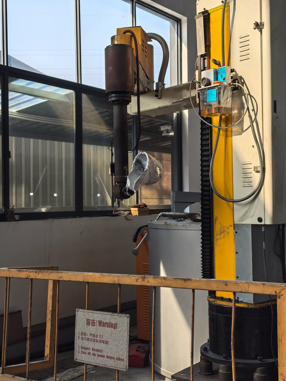 Automated pouring robot scooping molten aluminum for gravity casting